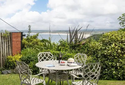 a table with chairs and a hat on it at The View in Carbis Bay