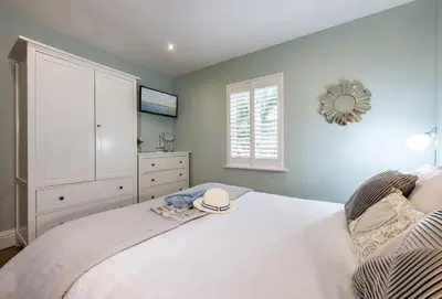 a bedroom with a white bed with a hat on it at The View in Carbis Bay