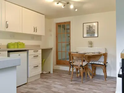 a kitchen with a table and a dining room at Millys Nook in St Austell