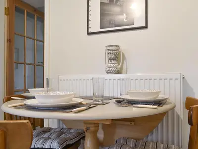 a dining room table with bowls and plates on it at Millys Nook in St Austell