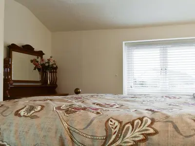 a bedroom with a bed with a window and a mirror at Millys Nook in St Austell