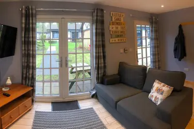 a living room with a couch and a sliding glass door at 41 Tudor Court in Hayle