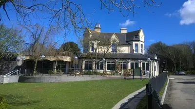 a large white house with a lawn in front of it at 41 Tudor Court in Hayle