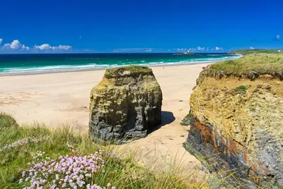 a large rock sitting on a beach next to the ocean at 41 Tudor Court in Hayle