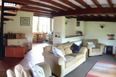 a living room with two couches and a table at Cottage Barn, Jacobstow in Bude