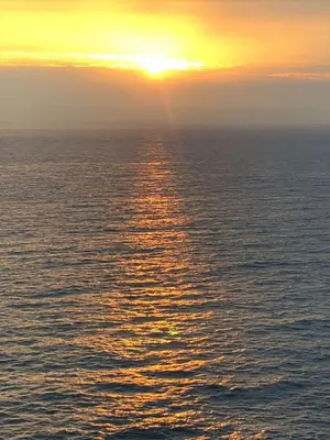a sunset over the ocean with the sun setting at Cottage Barn, Jacobstow in Bude