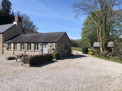 a stone house with a picnic table in front of it at Mimi's Cottage in Liskeard