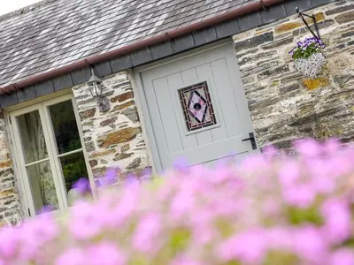 a white garage door with a mosaic of a dog on it at Mimi's Cottage in Liskeard
