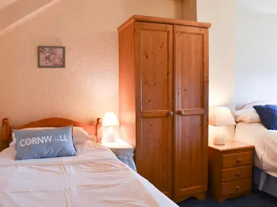 a bedroom with a bed and a wooden cabinet at Holly - Ukc4243 in Lanreath