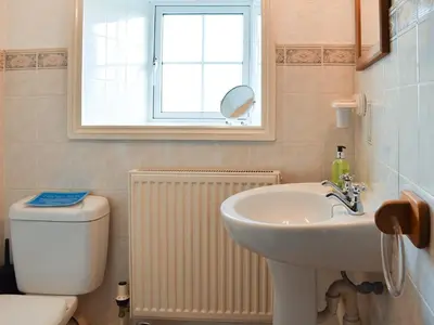 a bathroom with a sink and a toilet and a window at Holly - Ukc4243 in Lanreath