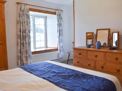 a bedroom with a bed and a dresser and a window at Holly - Ukc4243 in Lanreath