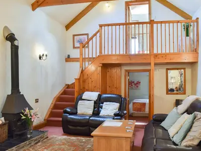 a living room with a couch and a staircase at Ricann - Ukc4244 in Lanreath