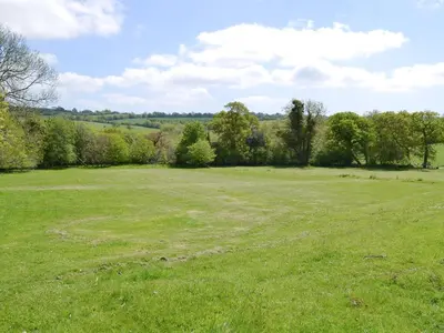 a large grass field with trees in the background at Ricann - Ukc4244 in Lanreath