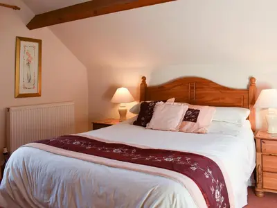 a bedroom with a large bed and two lamps at Ricann - Ukc4244 in Lanreath