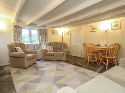 a living room with two chairs and a table at 2 Rose Cottages in Looe