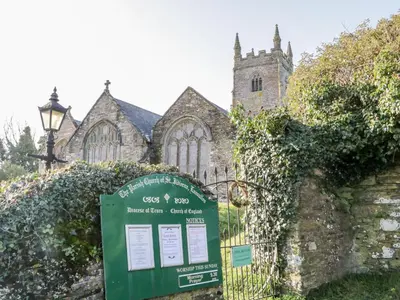 a church with a sign in front of a fence at 4 Rose Cottages in Looe