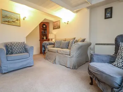 a living room with two chairs and two couches at 4 Rose Cottages in Looe
