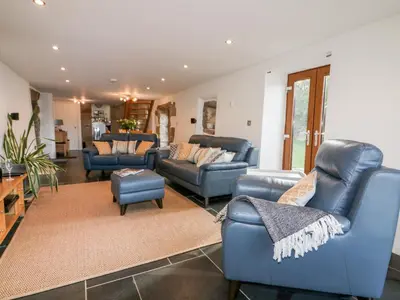 a living room with blue couches and chairs at Sleepy Fox in Bodmin
