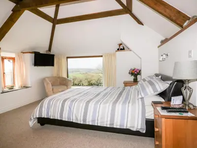 a bedroom with a bed and a window at Sleepy Fox in Bodmin