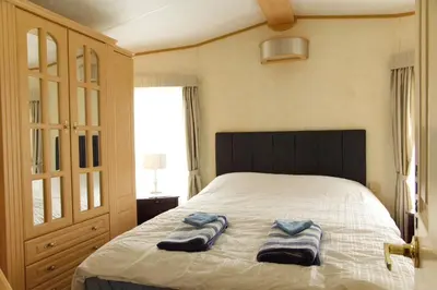a bedroom with a bed with two towels on it at Coosewartha Countryside Holiday Rental in Truro