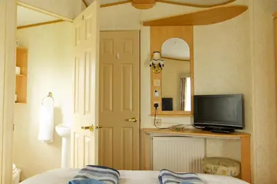 a bedroom with a bed and a television on a counter at Coosewartha Countryside Holiday Rental in Truro