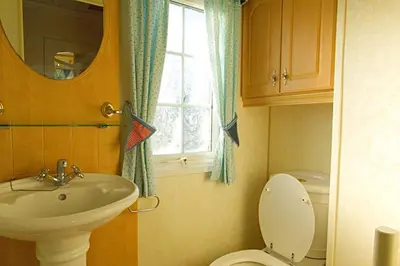 a bathroom with a sink and a toilet and a window at Coosewartha Countryside Holiday Rental in Truro
