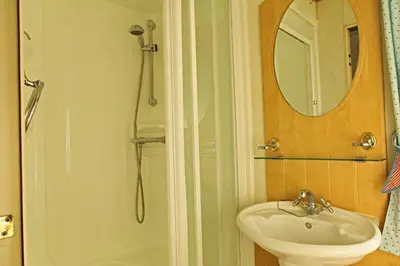 a bathroom with a sink and a shower and a mirror at Coosewartha Countryside Holiday Rental in Truro