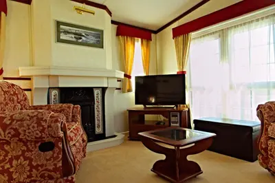 a living room with a fireplace and a tv at Coosewartha Countryside Holiday Rental in Truro