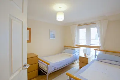 a bedroom with two beds and a window at Compass Point in Carbis Bay