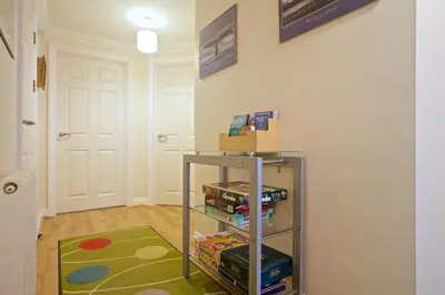 a room with a book shelf with books on it at Compass Point in Carbis Bay