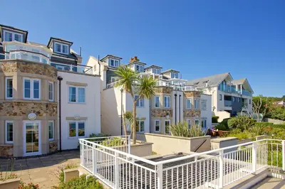a row of houses with palm trees in front of them at Compass Point in Carbis Bay