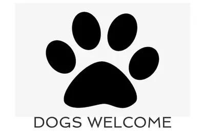 a black dog pawprint icon with the words dogs welcome at BY THE BEACH, The Quies, Beach House in St Merryn