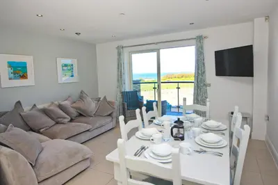 a living room with a white table and a couch at BY THE BEACH, The Quies, Beach House in St Merryn