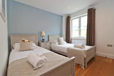 a bedroom with two beds with towels on them at APARTMENT BY THE BEACH, courtyard garden in St Merryn