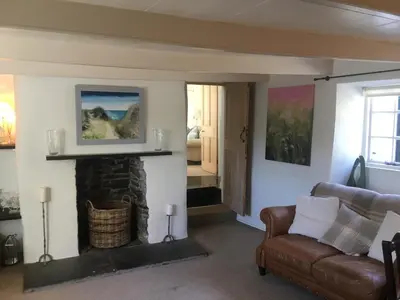 a living room with a couch and a fireplace at The Thatched Cottage in Truro