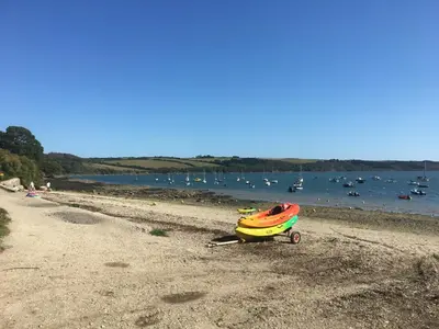 a boat on a beach with boats in the water at The Thatched Cottage in Truro