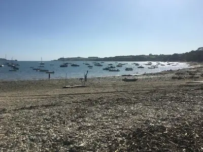 a beach with boats sitting in the water at The Thatched Cottage in Truro