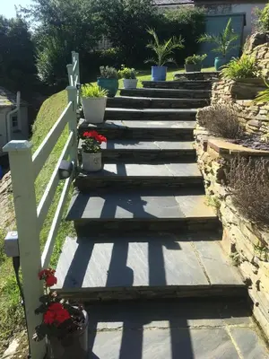 a set of stairs with potted plants on them at The Thatched Cottage in Truro