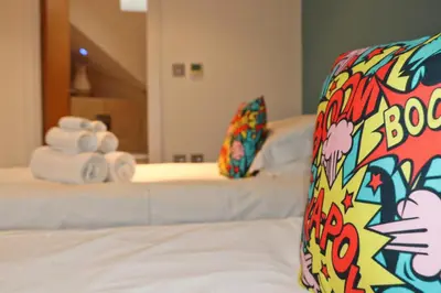 a hotel room with two beds with towels on them at STYLISH, BEACHSIDE apartment, sea views in St Merryn