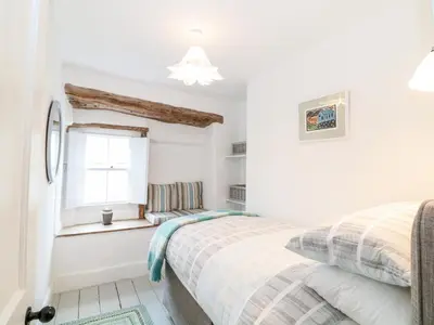 a bedroom with a bed and a window at 1 Jubilee Cottage in Tintagel