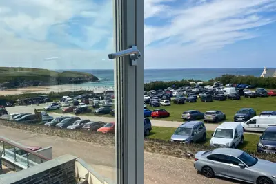 a bunch of cars parked in a parking lot at SEA VIEWS, beachside apartment with balcony in St Merryn