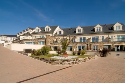 a large brick building with a lot of windows at SEA VIEWS, beachside apartment with balcony in St Merryn