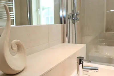 a bathroom with a shower and a sink at SEA VIEWS, beachside apartment with balcony in St Merryn