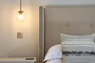 a bedroom with a bed with a lamp and a pillow at CLOSE TO BEACH, dogs welcome, private garden in St Merryn