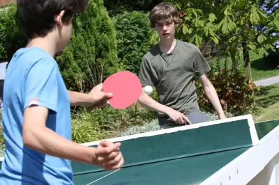 two young men playing a game of ping pong at Tehidy Holiday Park Wigwam Camping Cabins in Illogan