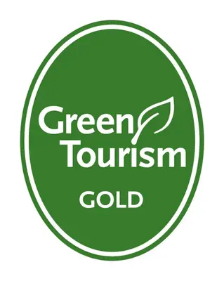 a green tournament gold sign in a green circle at Tehidy Holiday Park Wigwam Camping Cabins in Illogan
