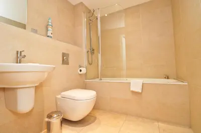 a bathroom with a toilet and a sink and a shower at APARTMENT BY THE BEACH The Foxcove in St Merryn