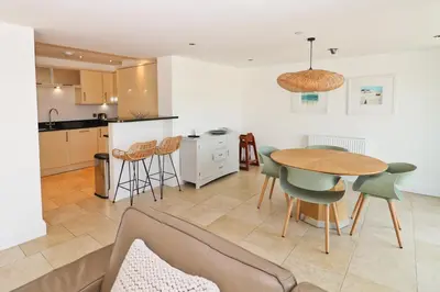 a kitchen and living room with a table and chairs at APARTMENT BY THE BEACH The Foxcove in St Merryn