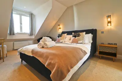 a bedroom with a large bed with towels on it at Contemporary beachside apartment in St Merryn