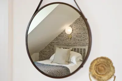 a mirror with a bed in a room at Contemporary beachside apartment in St Merryn